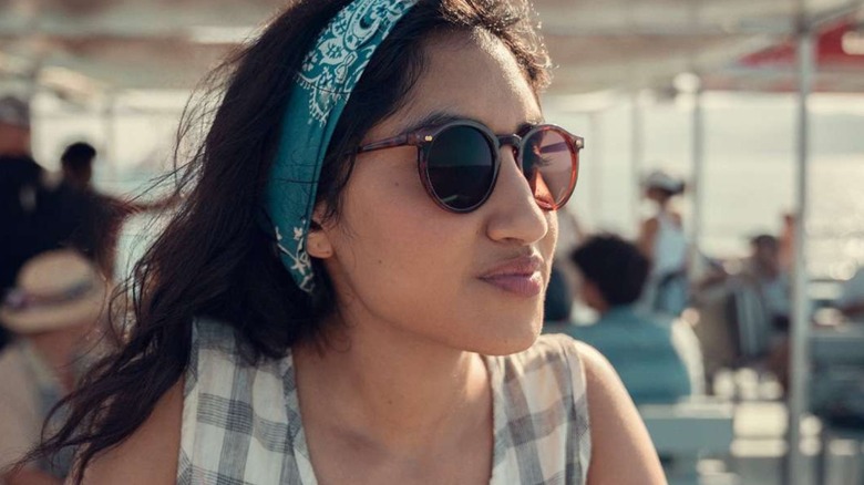 Emma wearing sunglasses and a bandanna on a ferry in One Day