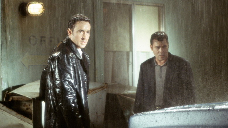 Ed and Rhodes standing in the rain outside the motel in "Identity"