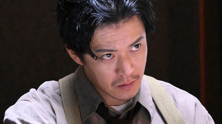 Kenji Okamoto looking up during an interrogation
