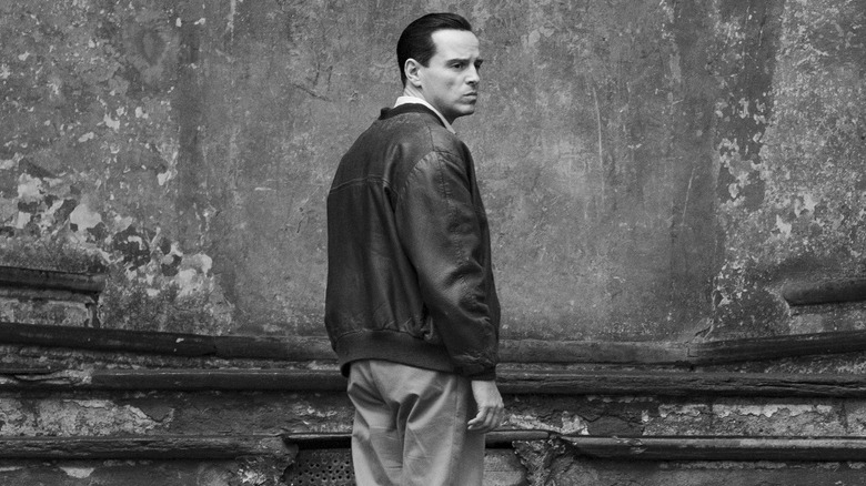 Tom Ripley standing on ancient steps in Italy, looking nervously over his shoulder in "Ripley" (2024)