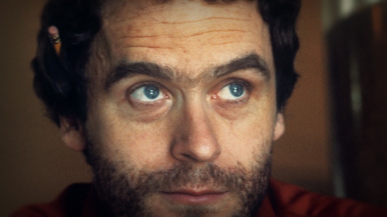Ted Bundy with a pencil tucked behind his ear, looking up