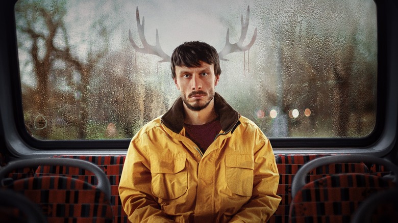 Donny sitting in the back seat of a bus with antlers drawn in the condensation behind him in Baby Reindeer
