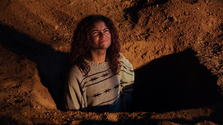 Rue in a hole squinting at someone on Euphoria