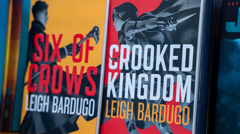 Two books side-by-side, the Canadian hardcover covers of "Six of Crows" and "Crooked Kingdom" by Leigh Bardugo