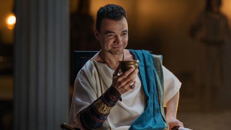 Ashur sitting cozily in "Spartacus: House of Ashur" (2025)