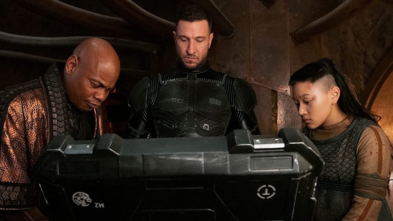 Master Chief and two of his allies inspecting a package in Halo (2022)