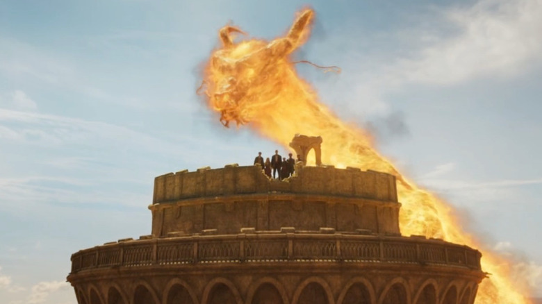 A fiery dragon circles a tower in "The Wheel of Time" (2021-2025)