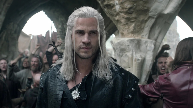 Geralt walks through a crowd in The Witcher