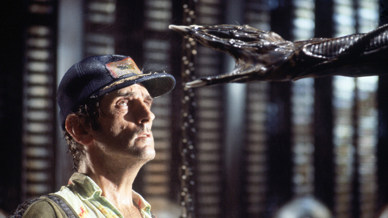An alien hand reaches toward Brett in Alien (1979)