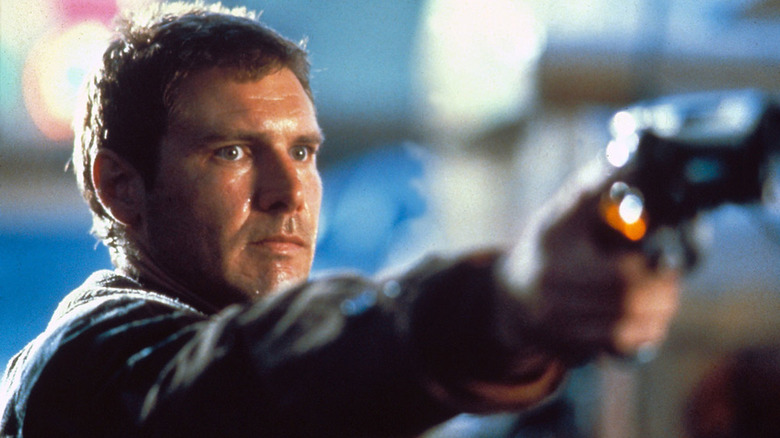 Rick Deckard aiming a handgun and grimacing in "Blade Runner" (1982)