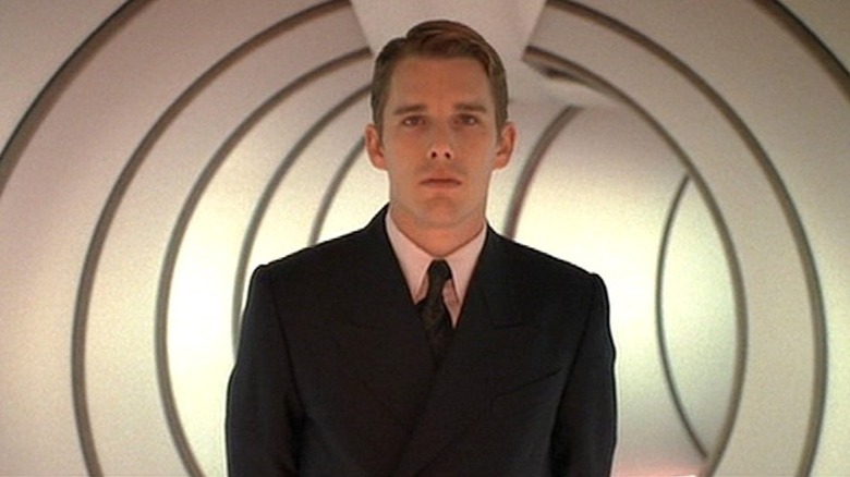 Vincent standing in a round hallway in a suit in "Gattaca" (1997)