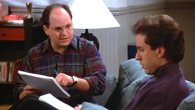 George Costanza and Jerry Seinfeld writing on couch
