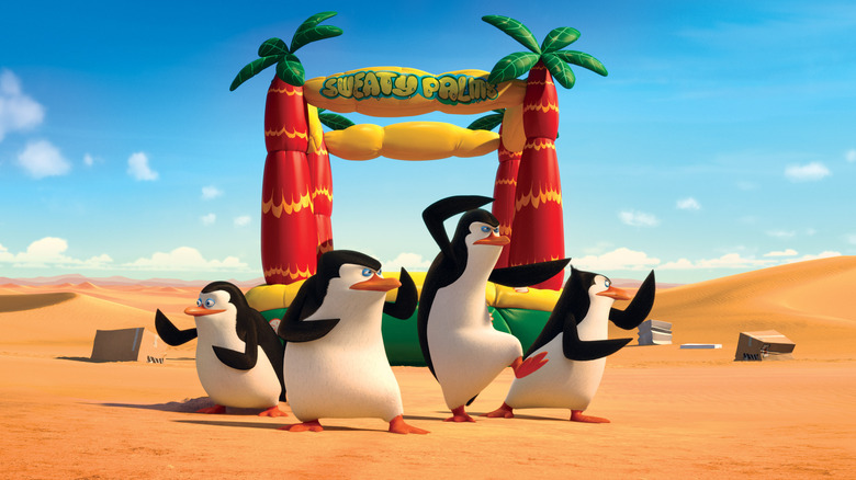 The titular leads of "Penguins of Madagascar" posing in front a bounce house