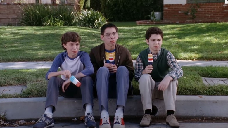 Sam, Bill, and Neal sitting on a curb in Freaks and Geeks (1999)