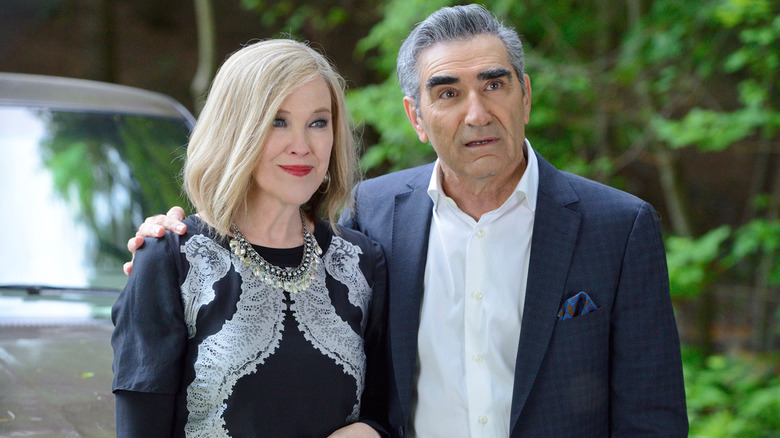 Johnny with his arm around a smiling Moira in Schitt's Creek (2015)