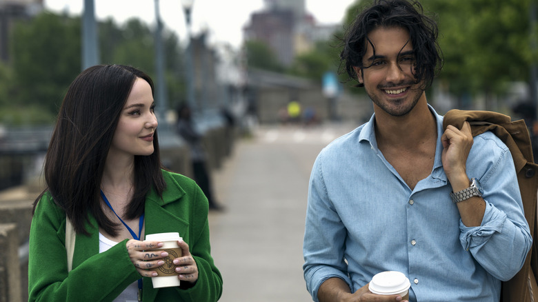 Ciara and Oliver walking with coffees in 56 Days