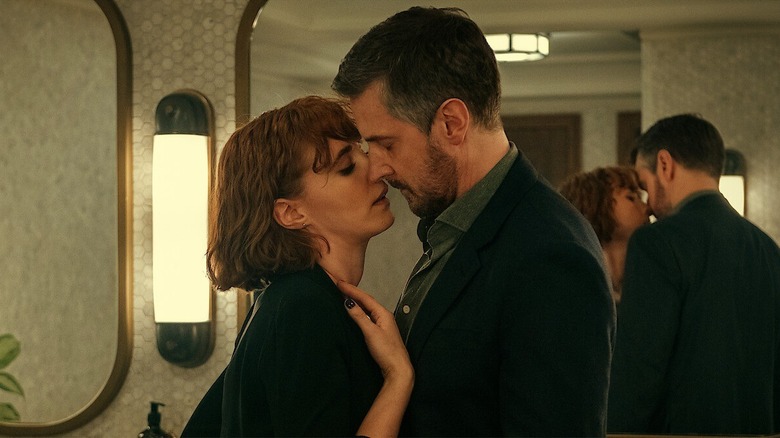 William and Anna kissing next to some mirrors in Obsession