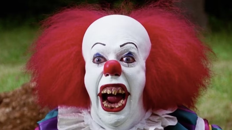 A laughing Pennywise shows his teeth in "It" (1990)