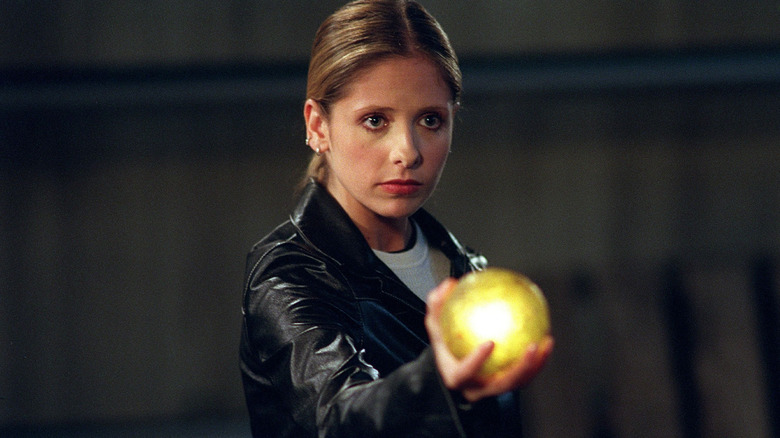 Buffy holds up a yellow glowing orb on "Buffy the Vampire Slayer" (1997-2003)