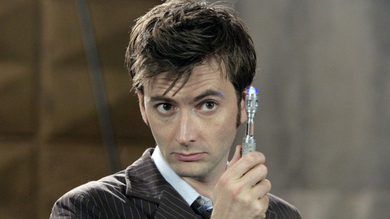 The 10th Doctor holds his Sonic Screwdriver in 
