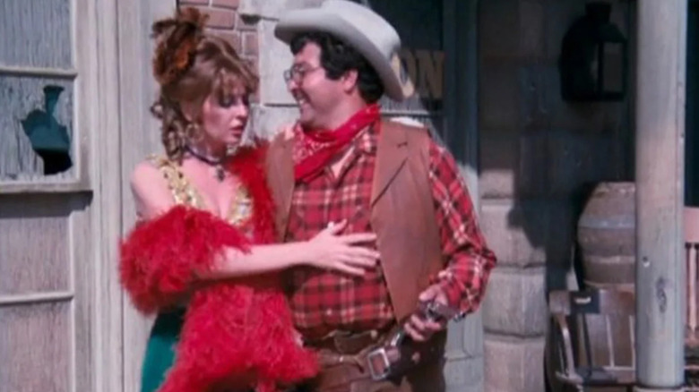 A brothel worker hangs on a customer dressed as a cowboy in Beyond Westworld (1980)