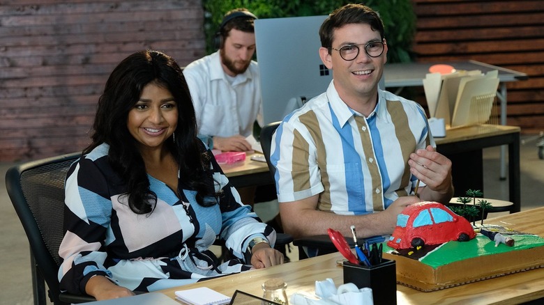 Ryan at Kim sitting at a desk and smiling in Special