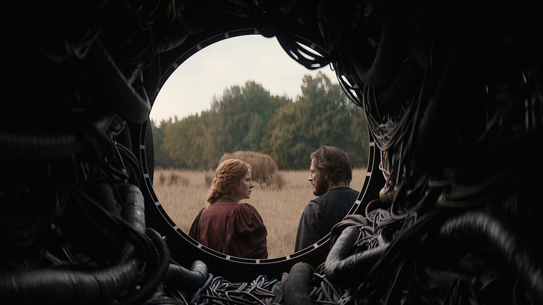 Maura and Eyk seen through a hole in a structure on 1899