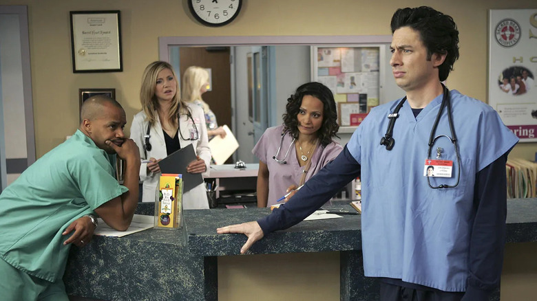 JD looking confused with Turk Elliot and Carla behind him on Scrubs