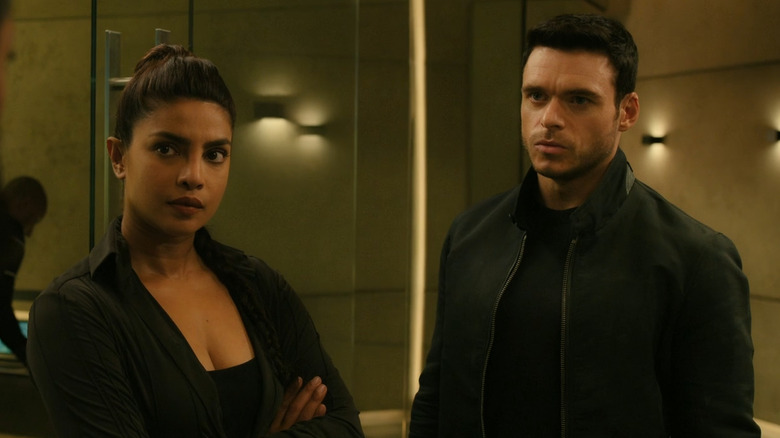 Nadia and Mason looking at someone talking in Citadel (2023)