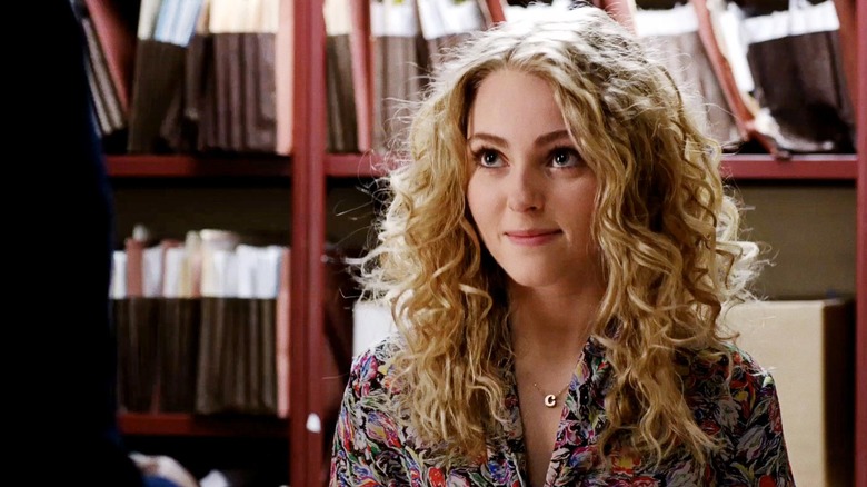 Carrie in a flower print shirt in front of shelves on The Carrie Diaries