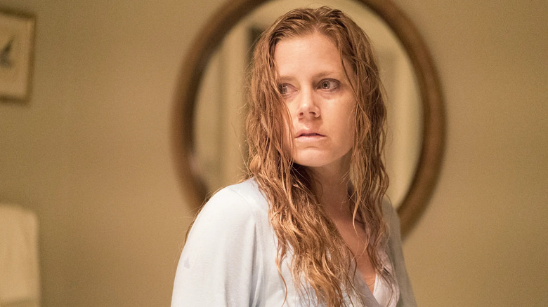 Camille with wet hair looking over her shoulder frightened in Dark Objects