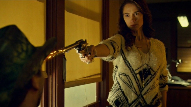 Wynonna holds a gun to a man's face in "Wynonna Earp" (2016-2021)