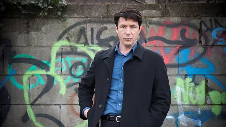 John Boy in front of graffiti in Love/Hate
