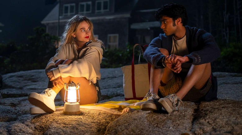 Cady and Gat sitting on the beach by a fire in We Were Liars
