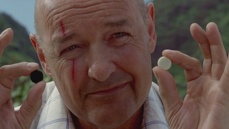 John Locke holding black and white chess pieces in Lost