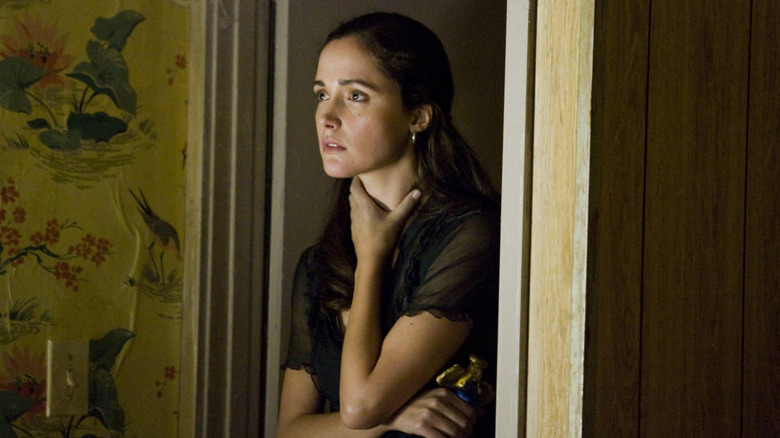 Diana Wayland nervously holding onto neck in bedroom doorway in "Knowing"