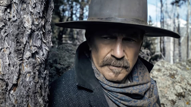 Hayes Ellison looks out from behind a tree in Horizon: An American Saga - Chapter 1 (2024)