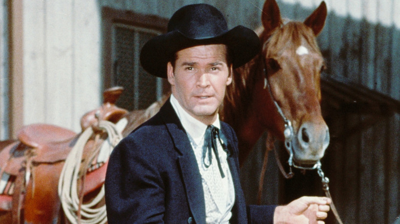 Bret Maverick standing next to a horse in 