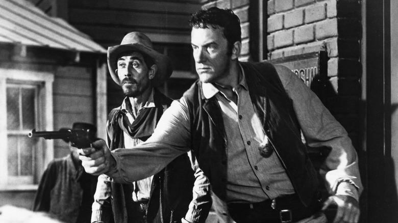 Marshal Matt Dillon, beside Deputy Festus Haggen, pulling his gun on Gunsmoke (1955-1975)