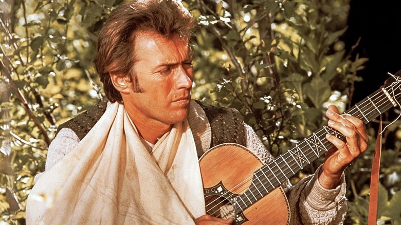 Pardner strumming a guitar in Paint Your Wagon (1969)