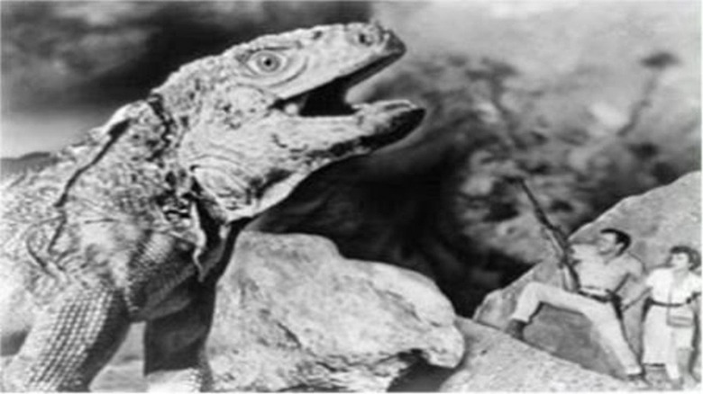 A pair of humans scuffling with the adversarial beast of King Dinosaur (1955)