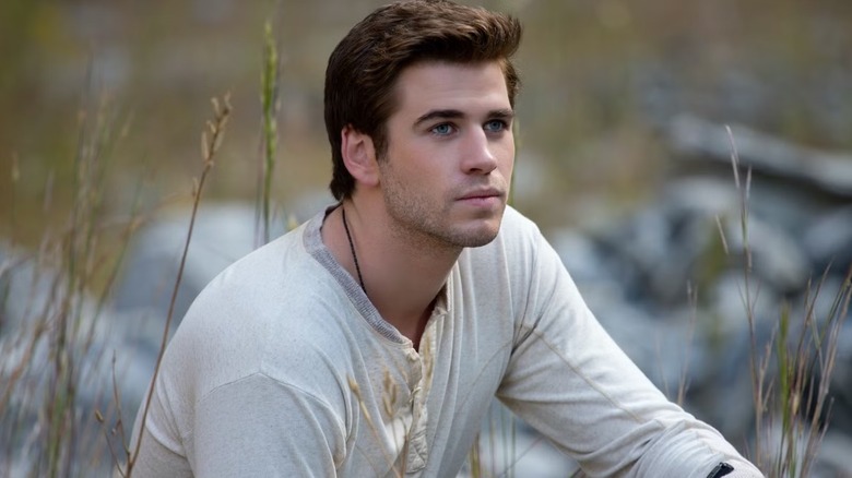 Gale sitting on some grass in "The Hunger Games"