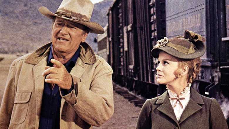 Lane and Mrs. Lowe on a train platform in The Train Robbers