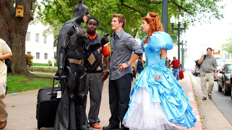 "Batman" with a suitcase talks to a couple guys and a girl in a princess dress in Disaster Movie (2008)
