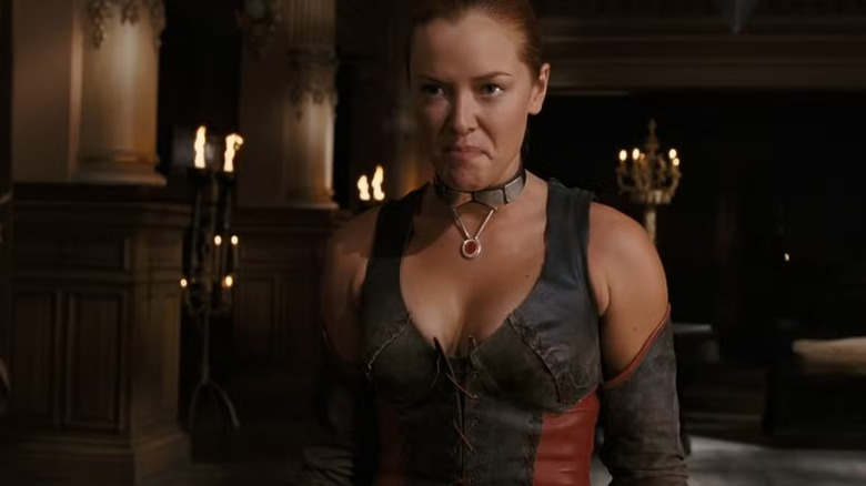 Rayne makes a unhappy face in a darkened room with candles