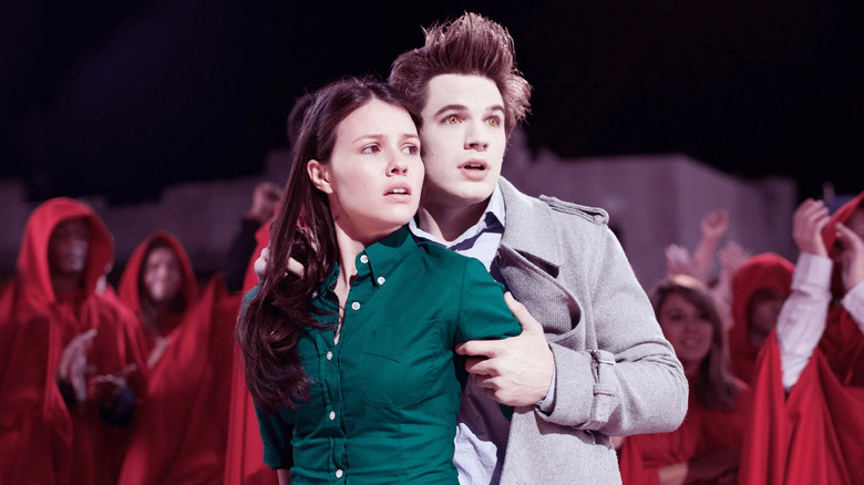 Edward holds Bella protectively while robed figures loom behind them