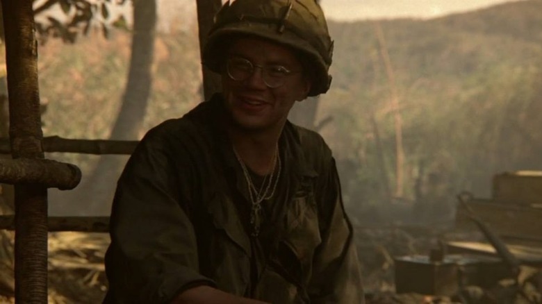Jacob smiling while seated on a village stoop