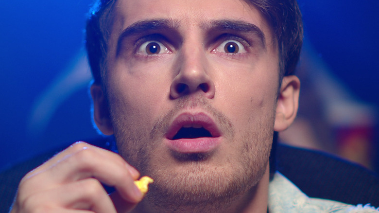 Man in a movie theater with a surprised expression