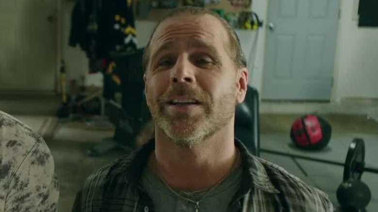 Doug in a garage smiling in "The Resurrection of Gavin Stone" (2017)