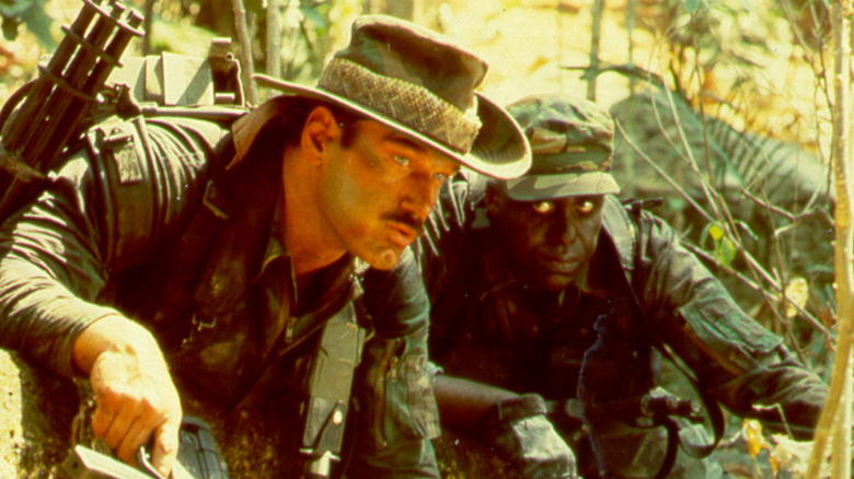Mac looks at Blain as they hide in the jungle in "Predator" (1987)
